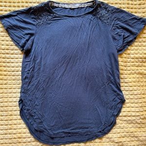 blue women’s blouse with winged sleeves and lace details